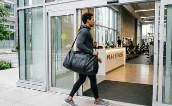Sleek premium gym bag sitting on a clean floor next to fitness gear.